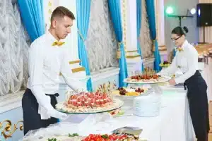 a man and woman serving platters