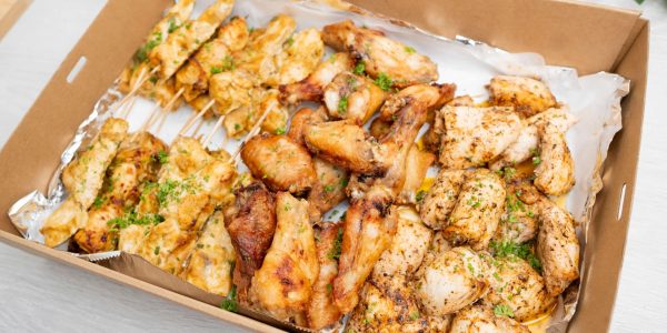 A platter filled with chicken skewers, wings, and breasts